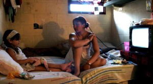 Prisoner Silvia Rodas Paniagua and her daughter sit in a cell at the Unidad (Unit) 33 prison in Los Hornos near La Plata, the capital of Buenos Aires Province in late October 2007. In this medium-security prison 273 female inmates, several of them pregnant, live with their 63 children who are allowed to remain with their mothers until they are four years old. Most of the prisoners are being held pending trial on charges of robbery, drug trafficking or murder. The prisoners complain about long delays before trial. In 2005 one prisoner died and two were hurt in a riot when inmates burned mattresses to protest transfers to other jails. Picture taken October 2007. EDITORS NOTE - ONE OF TEN IMAGES OF A PHOTO ESSAY ON A MEDIUM-SECURITY WOMEN PRISON IN LOS HORNOS, ARGENTINA. REUTERS/Carolina Camps (ARGENTINA)