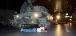 A man lies in front of a Turkish army tank at Ataturk airport in Istanbul, Turkey July 16, 2016. REUTERS/IHLAS News Agency NO SALES. NO ARCHIVES. TURKEY OUT. NO COMMERCIAL OR EDITORIAL SALES IN TURKEY.